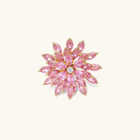 Pink cubic zirconia brooch in floral starburst design with palladium-plated copper setting on white background.