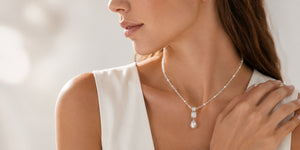 Woman wearing silver-tone necklace with a pear-shaped gemstone drop pendant, VRAEVA